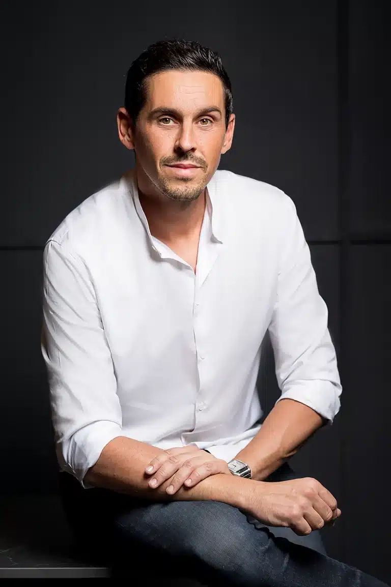 Portrait corporate d'Aurélien Auger, chef d'entreprise de la société Faabriq Rénovation, maître d'œuvre en chemise blanche sur fond noir, photographe professionnel spécialisé en portraits de dirigeants du bâtiment