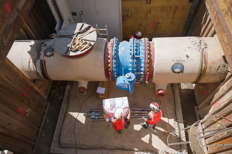 Détail d'un assemblage de canalisations industrielles avec vannes et raccords bleus, photographie technique BTP — Studio Chaillou Lyon