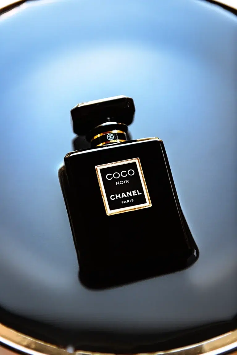 Packshot du flacon de parfum Coco Noir de Chanel sur fond sombre et surface réfléchissante, photographie commerciale produit luxe — Studio Chaillou Lyon