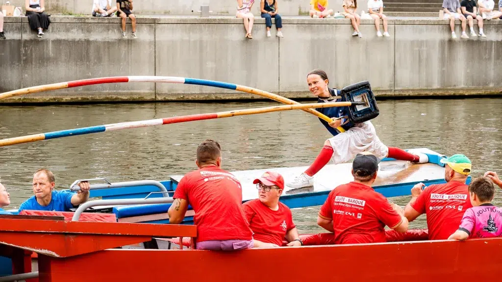 Joute sur barque en compétition sur la Saône à Lyon, joûteuse en action lors d'un duel, Ligue Auvergne-Rhône-Alpes — reportage photo événement sportif Studio Chaillou Lyon