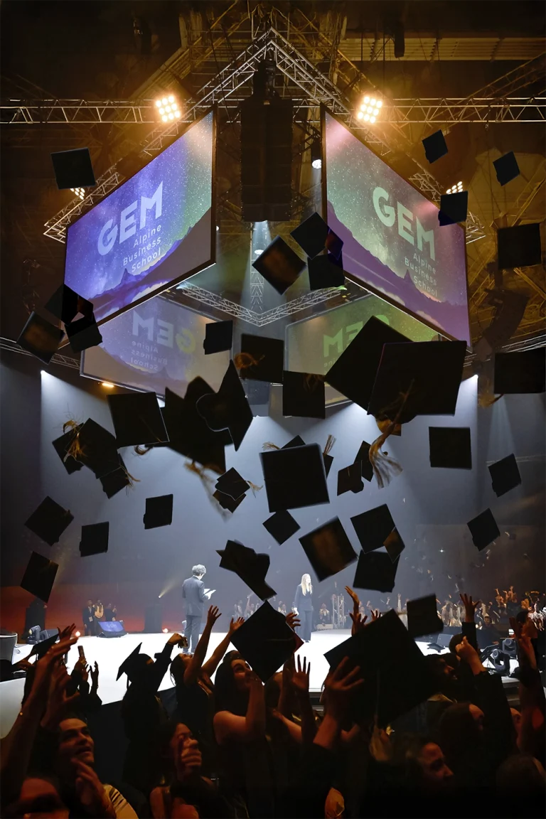 Diplômés en toge lors de la graduation ceremony de GEM qui lancent leurs toques en l'air. Reportage photo par Studio Chaillou, photographe remise de diplômes Lyon